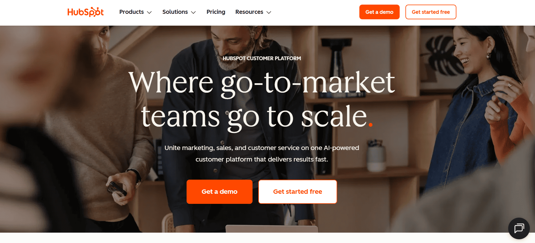 Smiling professionals meet in a modern office as the HubSpot site highlights Sales Analytics Tools for small teams scaling by 2026.